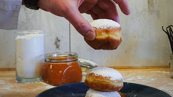 Krapfen im Interalpen Hotel - Koch stapelt Krapfen aufeinander